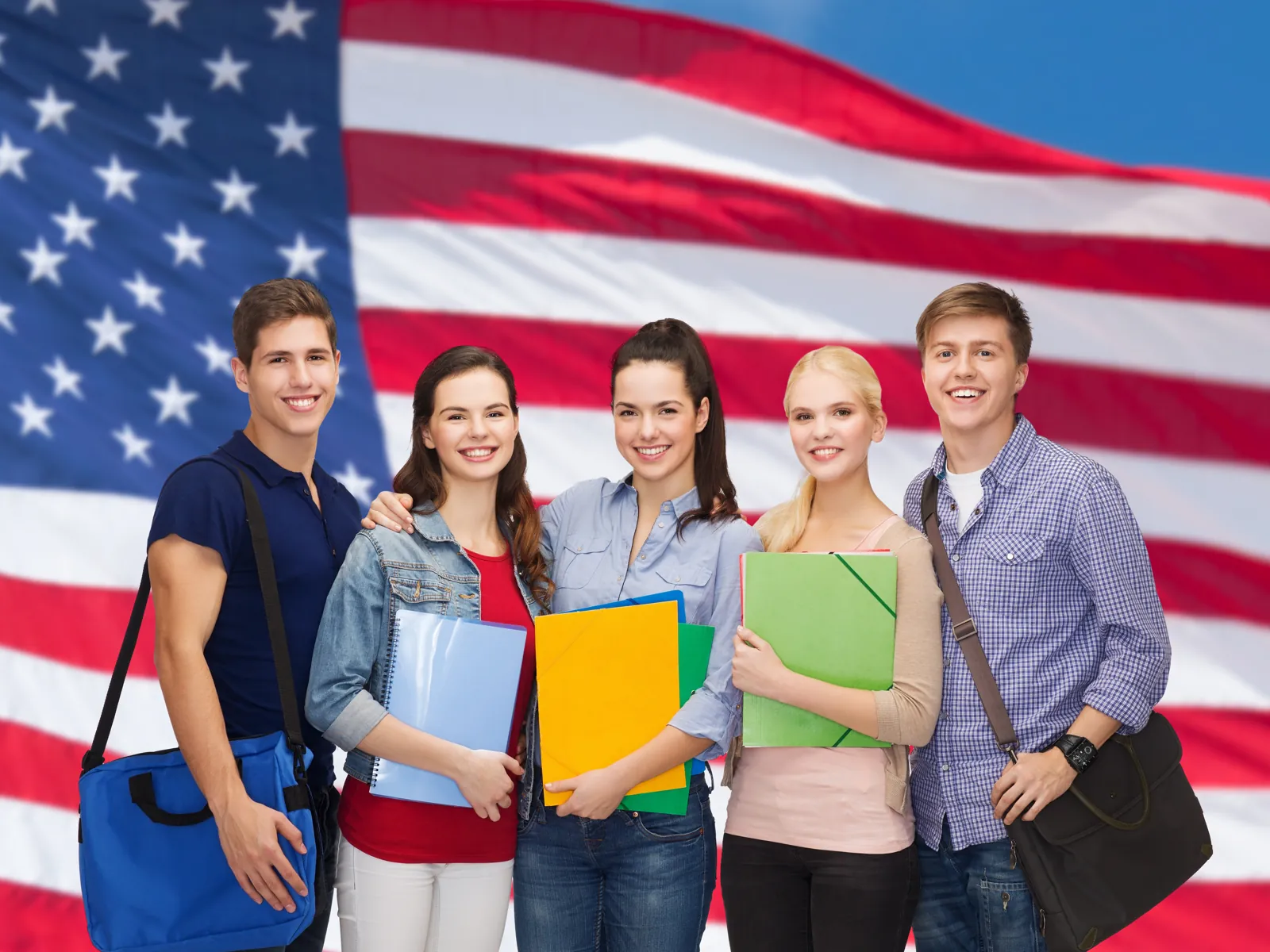Amerika'da eğitim için dosyalarıyla hazırlanan öğrenciler, Amerikan bayrağı önünde