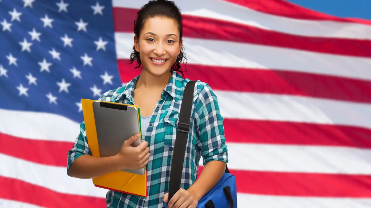 Amerikan bayrağı önünde dosya ve tabletiyle üniversite öğrencisi